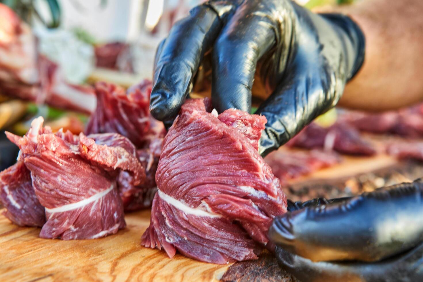 A variety of raw meat cuts, including ribs and tenderloin, displayed on a wooden board, ready for preparation and cooking photo