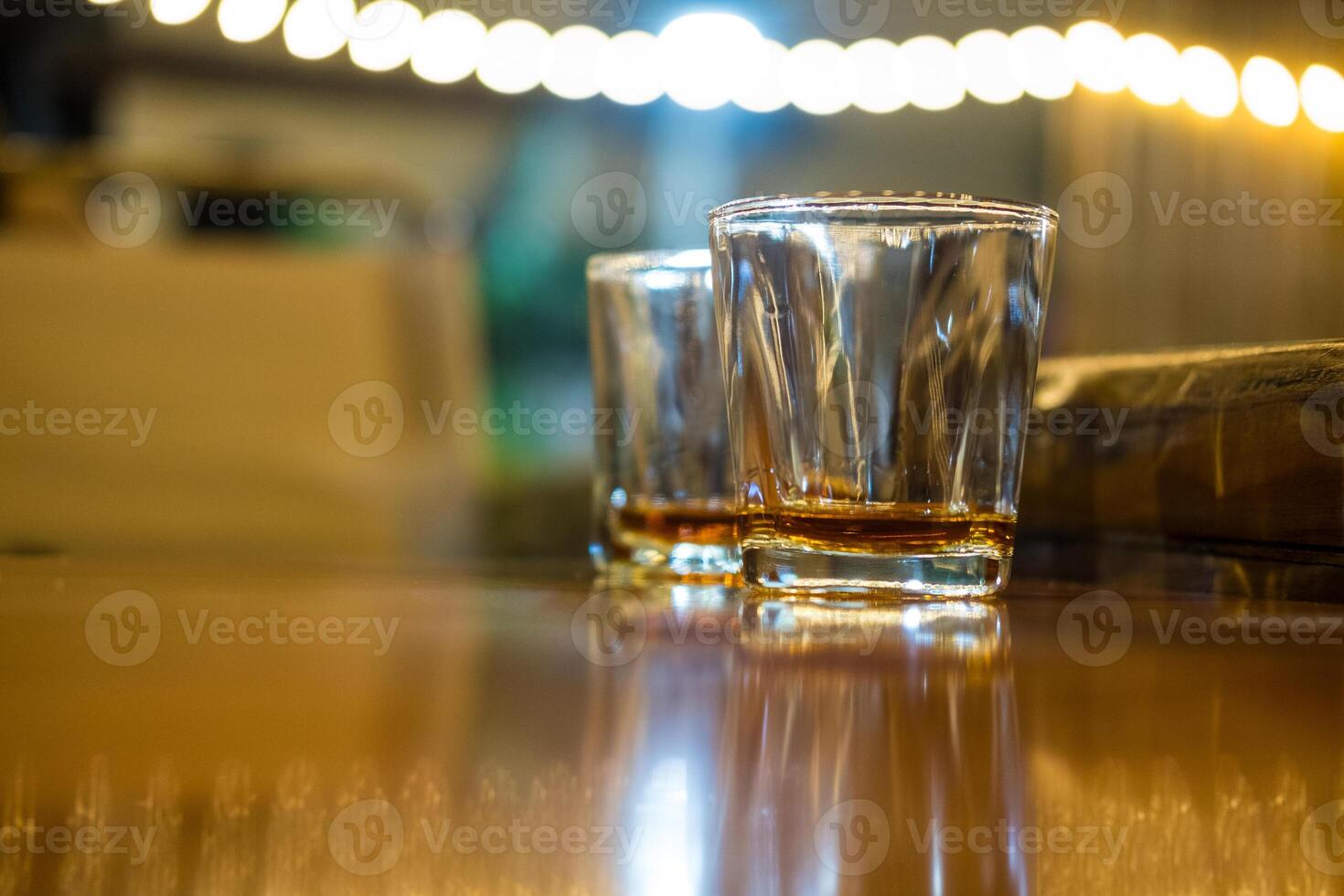 Vodka in shot glasses with a bokeh background. photo