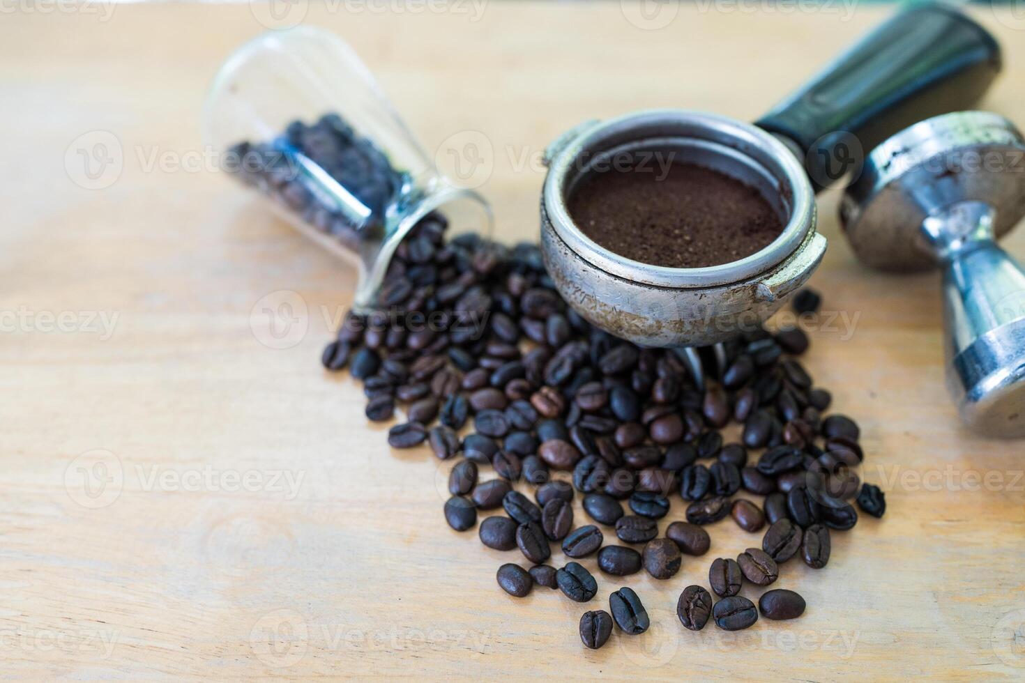 Ground coffee into portafilter and fresh roasted coffee bean photo