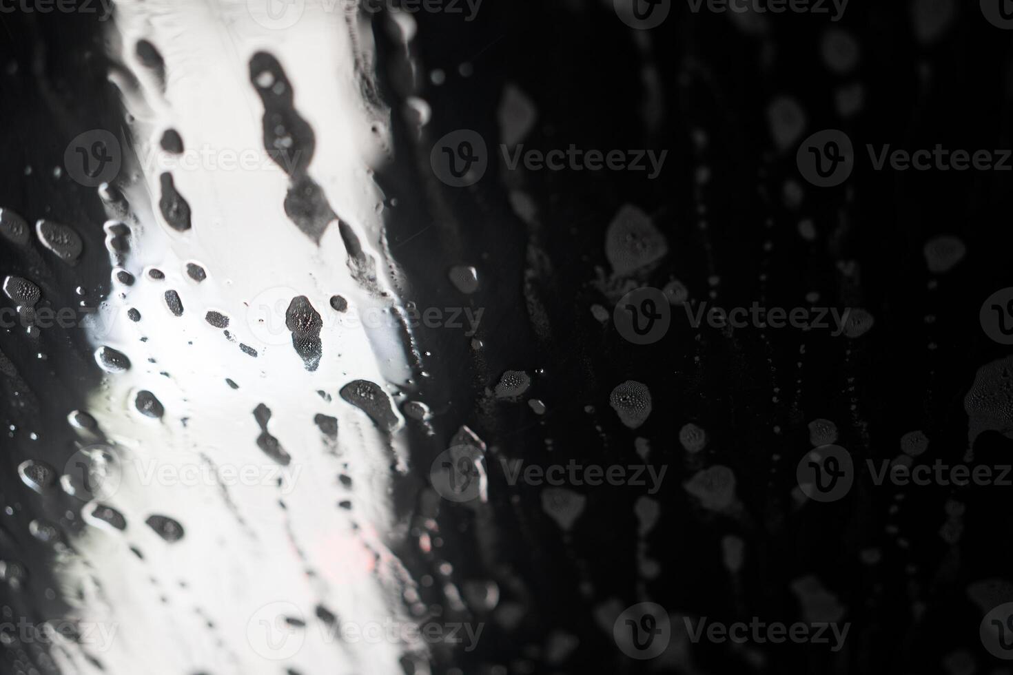 Soap sud wave pattern on car windshield photo