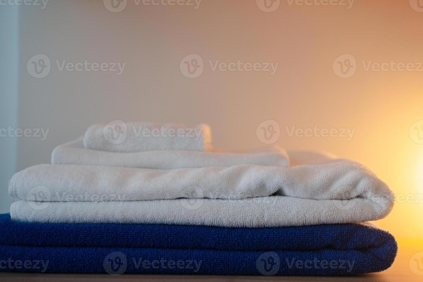Stack of two white towels and one blue towel clean folded. photo