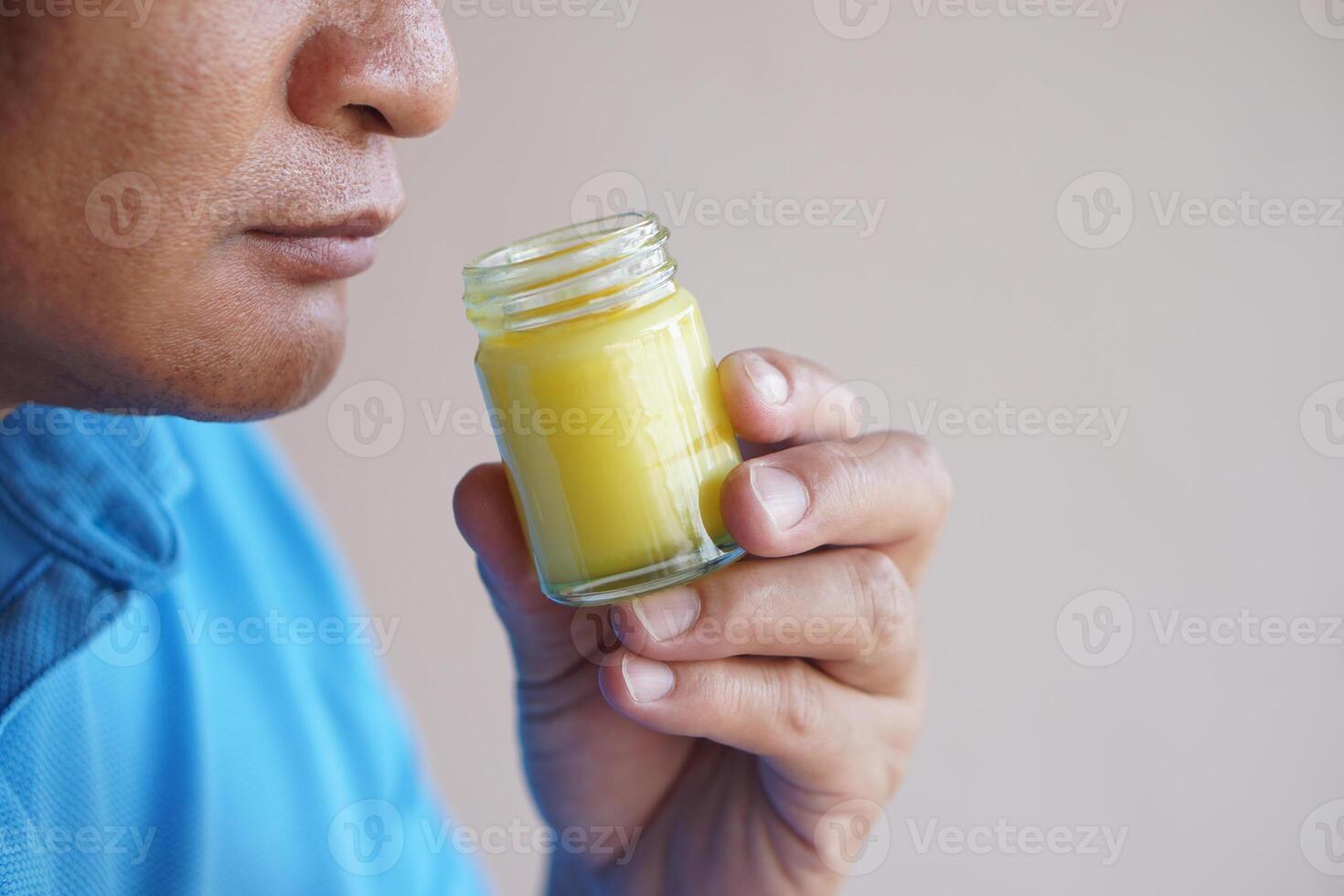 Close up man holds bottle of yellow balm to smell to relieve dizzy ,headache, emotional stress symptoms. Concept, healthcare. Thai local wisdom to use fragrant herbs to mix in ointment to therapy. photo