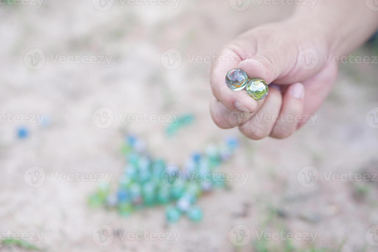 Closeup hand holds round small marble balls to play games. Concept, traditional childen play toy. Recreation activity to make concentrate for kids, fun and competition games photo