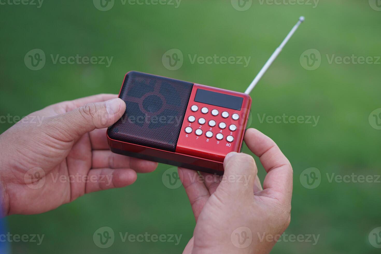 Hands hold portable mini radio. Concept, audio electronics for listening to music, songs or news from radio wave channel station. Analog amplifier for relaxation and lifestyle. photo