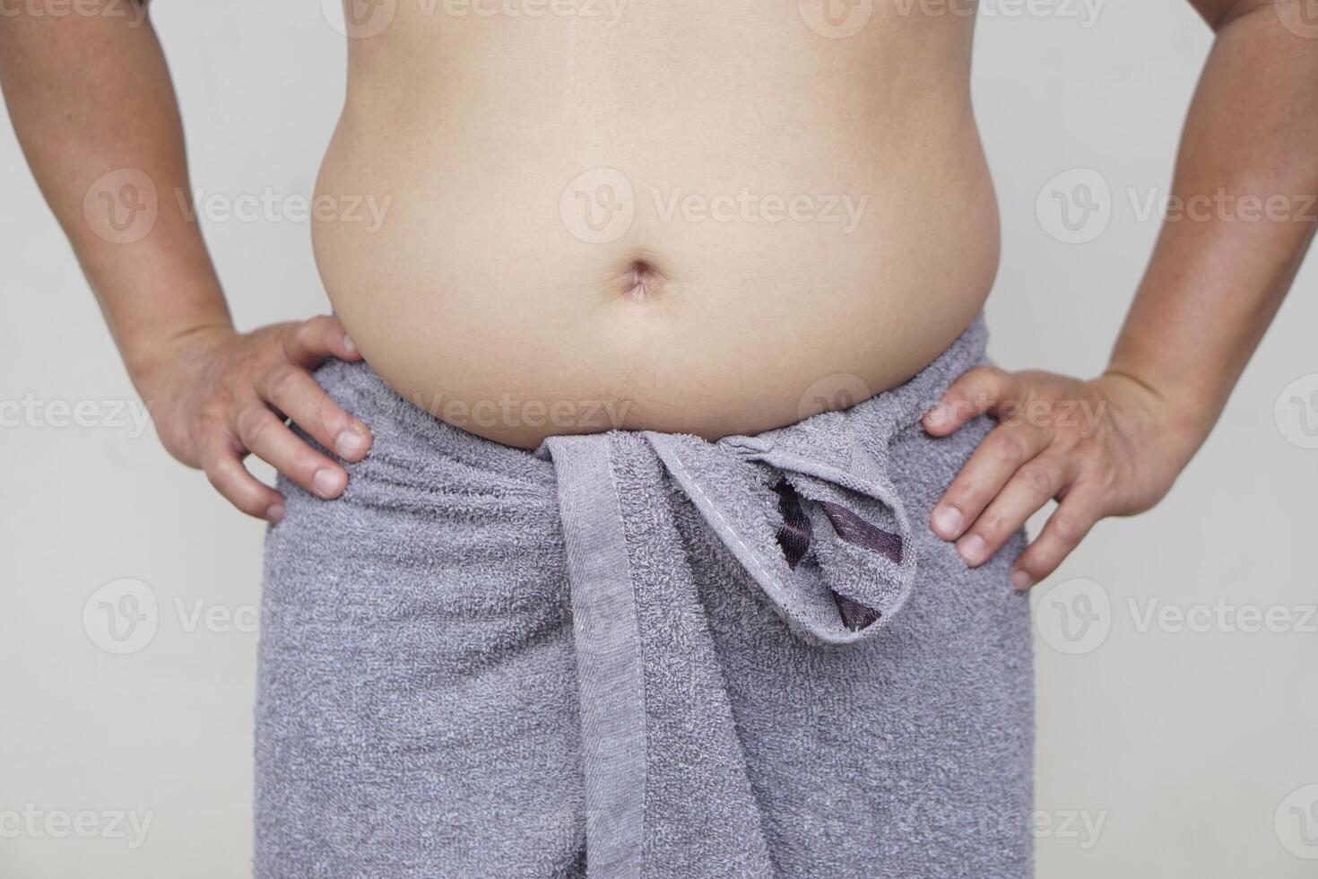 Close up man show his big, thick fat belly. Concept, fat, overweight, oversize waistline. Health problem of obesity, overweight in men can cause to diseases. photo
