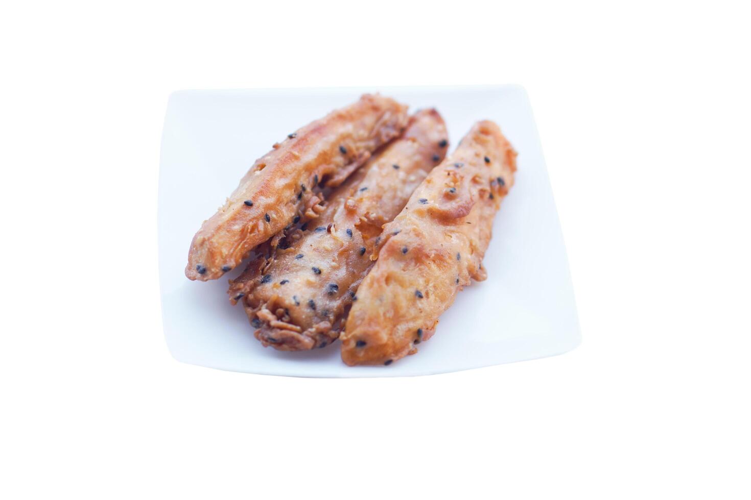 Homemade crispy deep fried sweet potato, topping with sesame, isolated on white background. Concept, deep fried food,delicious snack. Street food in Thailand. photo