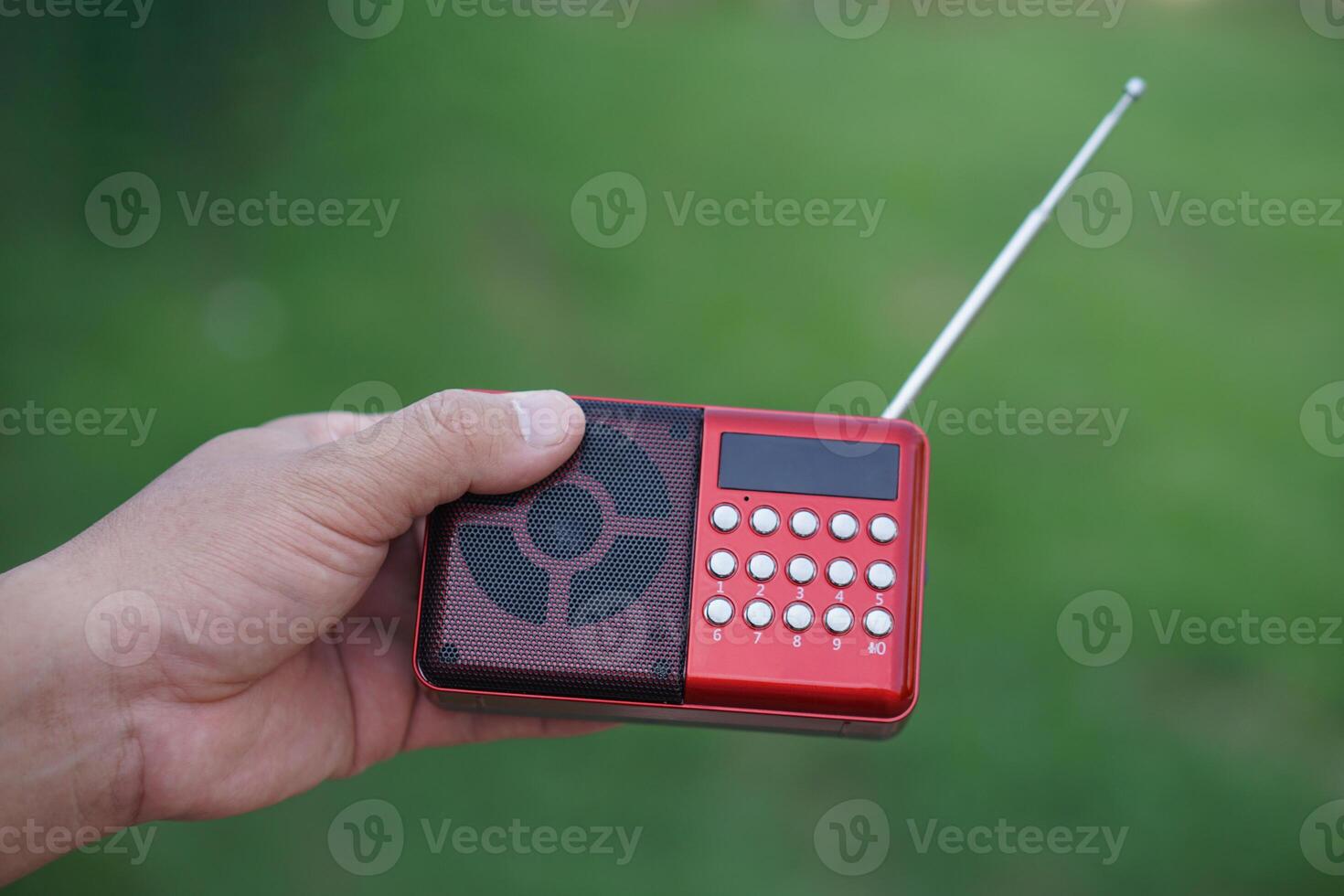 Hands hold portable mini radio. Concept, audio electronics for listening to music, songs or news from radio wave channel station. Analog amplifier for relaxation and lifestyle. photo