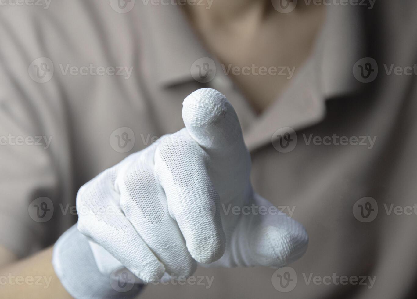 Man wearing white gloves, pointing finger photo