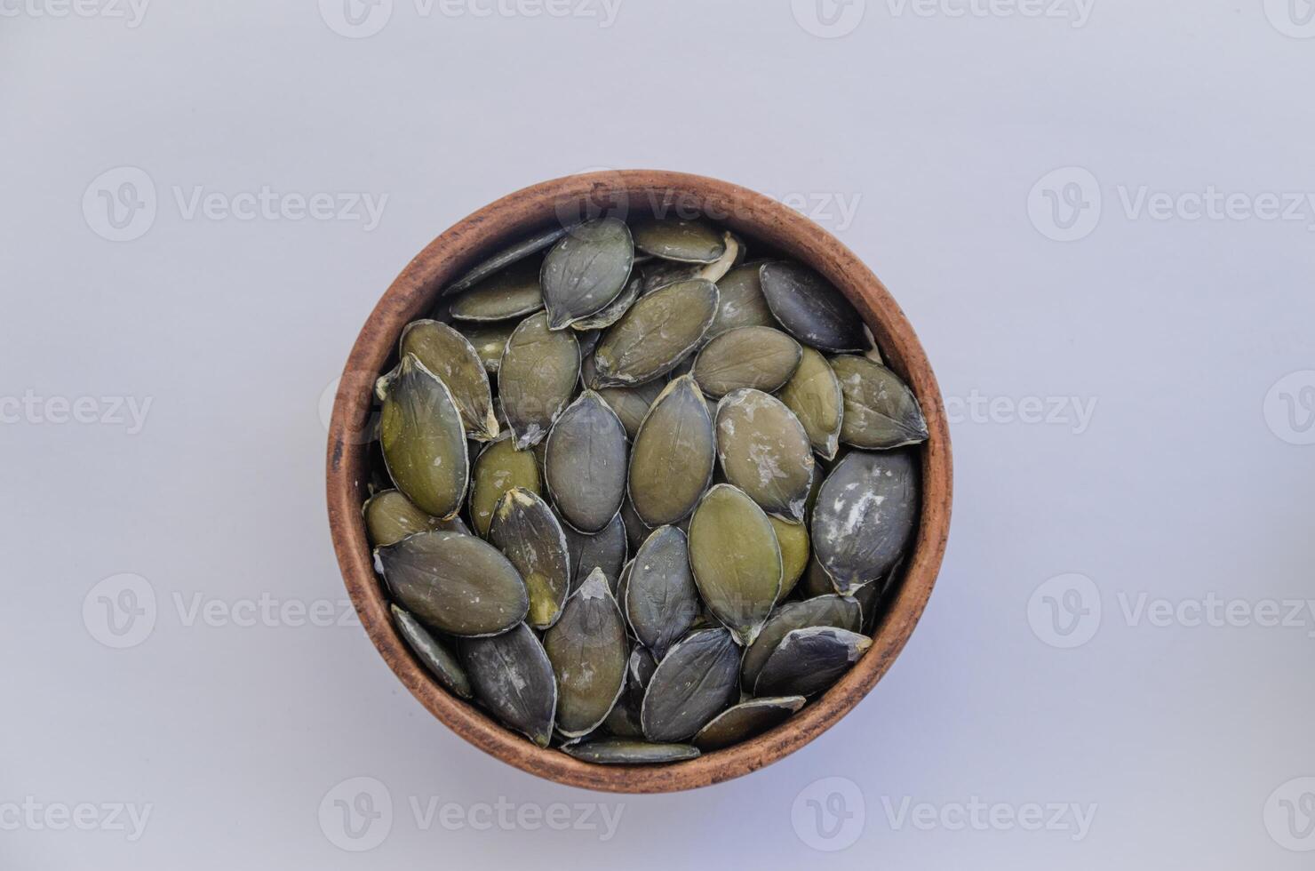 Pumpkin seeds peeled in a plate on a light background, Stirril gymnosperm pumpkin seeds. High quality photo
