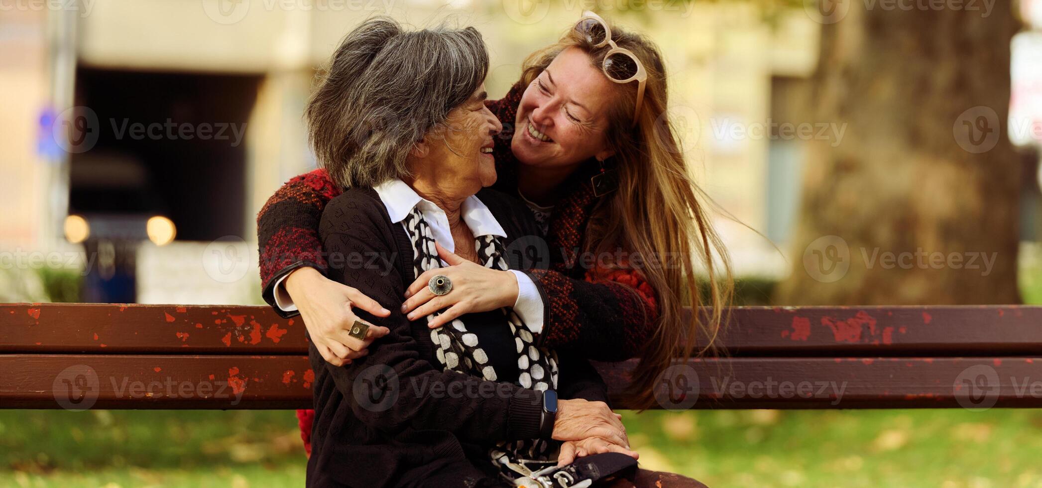 Embracing Generations. A Daughter's Love and Support for Her Senior Mother on a Sunny Day in the Park photo