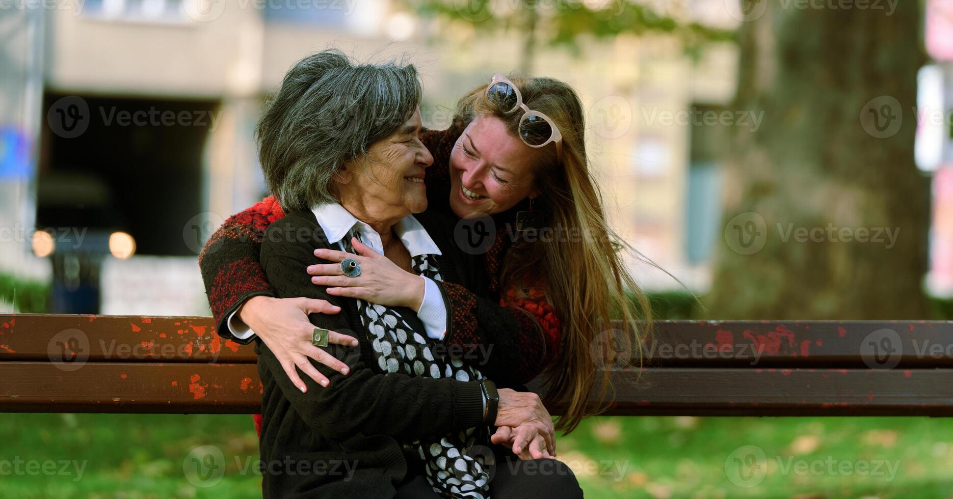 Embracing Generations. A Daughter's Love and Support for Her Senior Mother on a Sunny Day in the Park photo
