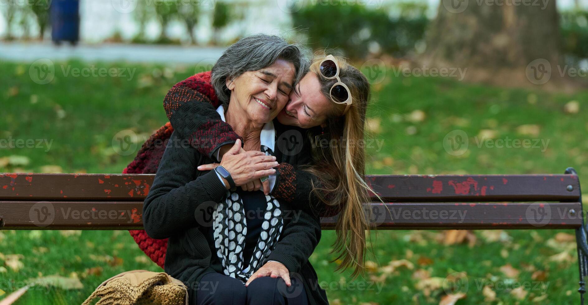 Embracing Generations. A Daughter's Love and Support for Her Senior Mother on a Sunny Day in the Park photo