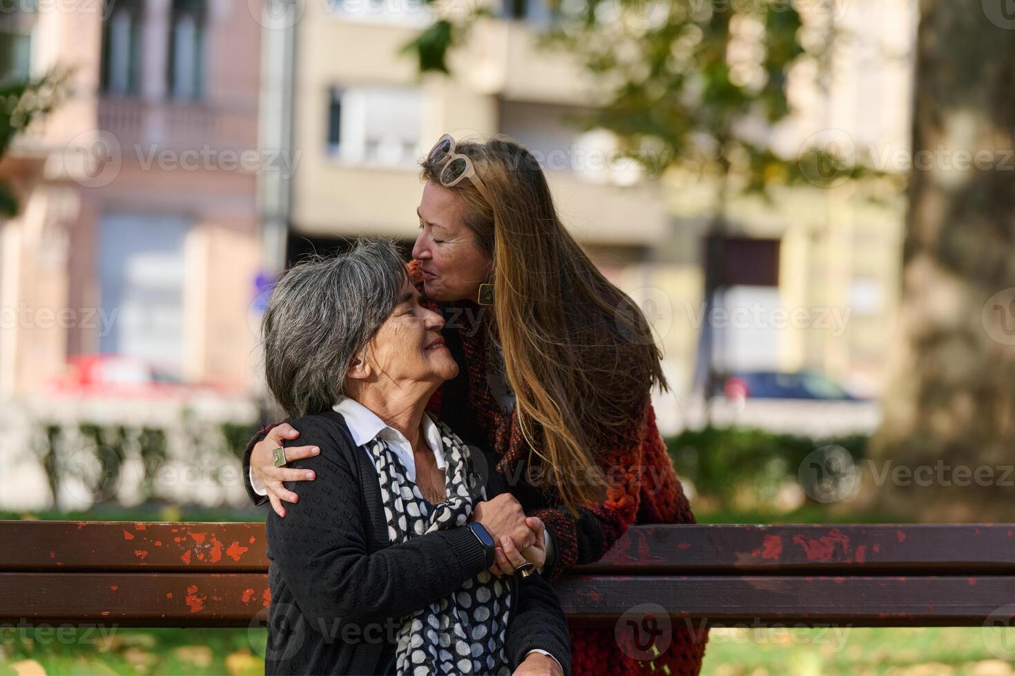 Embracing Generations. A Daughter's Love and Support for Her Senior Mother on a Sunny Day in the Park photo