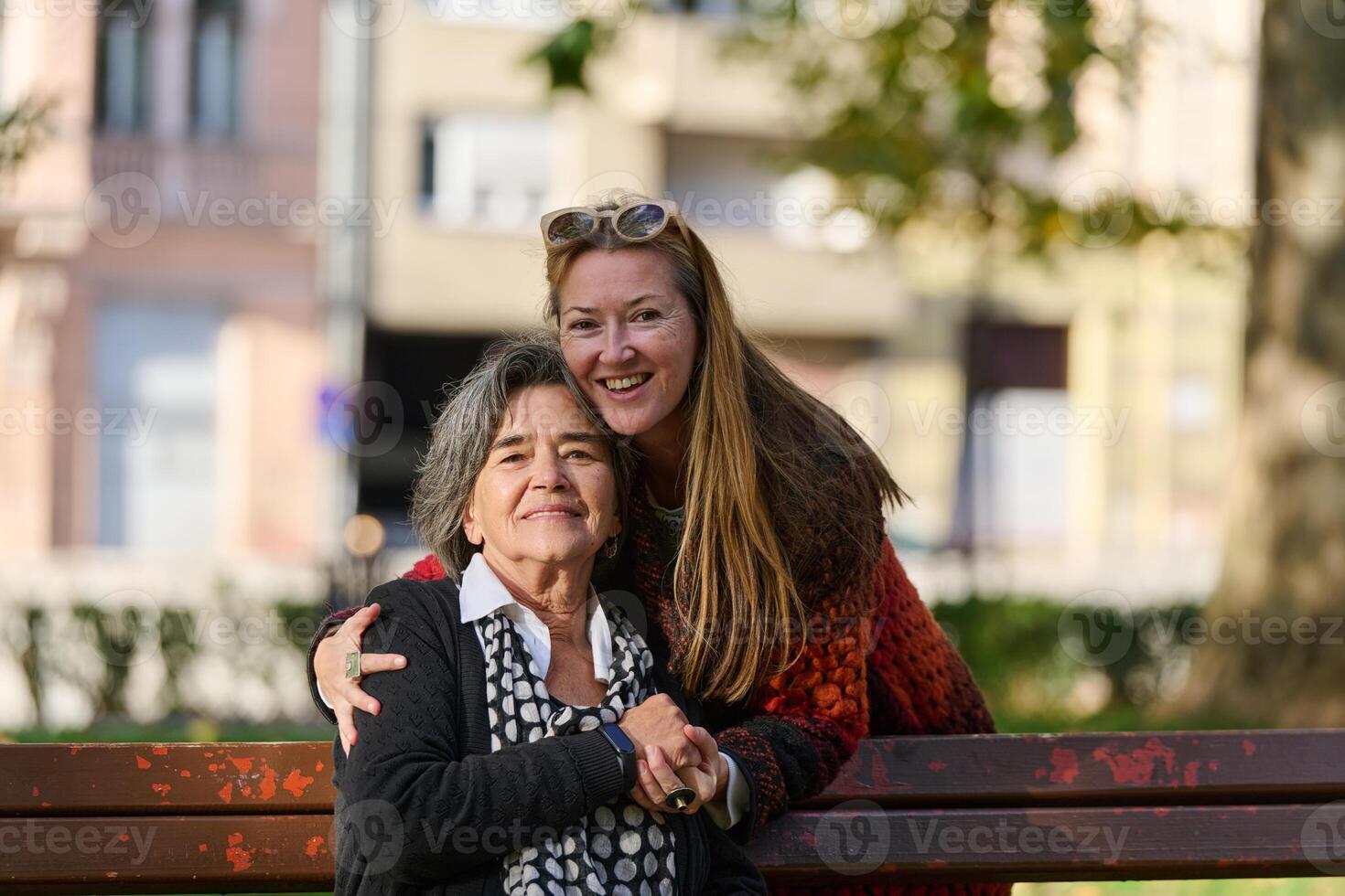 Embracing Generations. A Daughter's Love and Support for Her Senior Mother on a Sunny Day in the Park photo