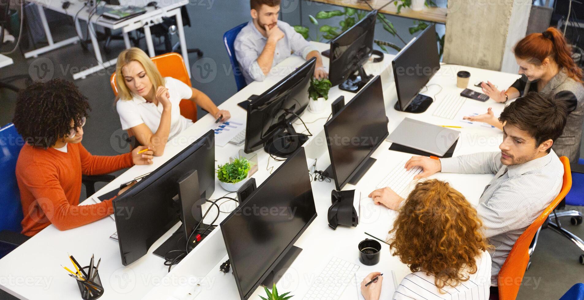 Group of young business people working together, sitting at coworking office, empty space photo