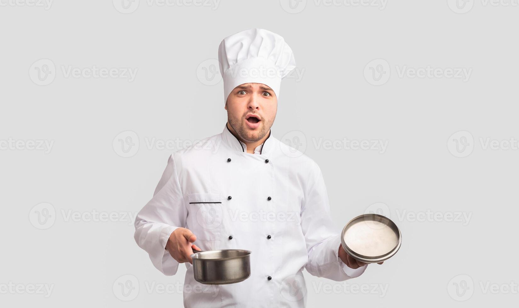 Oops. Puzzled Cook Man Opening Saucepan Looking At Camera Standing On White Studio Background. Panorama photo