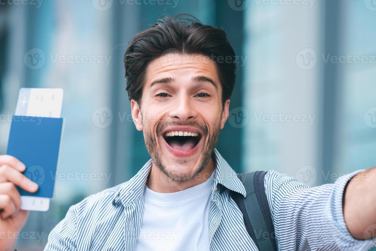 Finally adventure. Emotional guy enjoying new travel with passport and tickets, close up photo