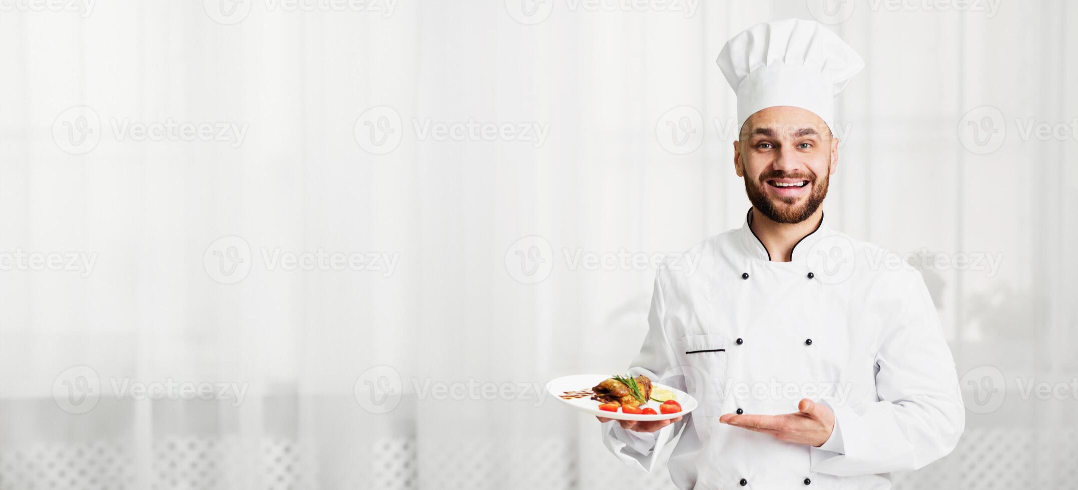 Chef Serving Food. Happy Cook Man Holding Plate With Chicken Presenting Dish Smiling At Camera Standing In Kitchen. Selective Focus photo