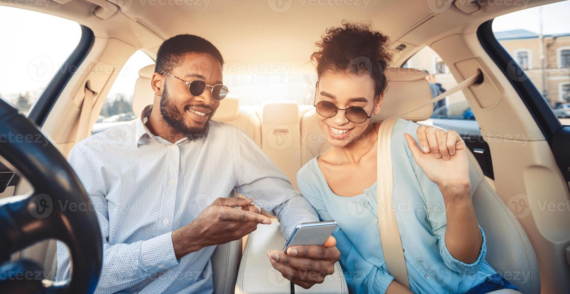 Young couple driving car and using digital map on smartphone, panorama photo