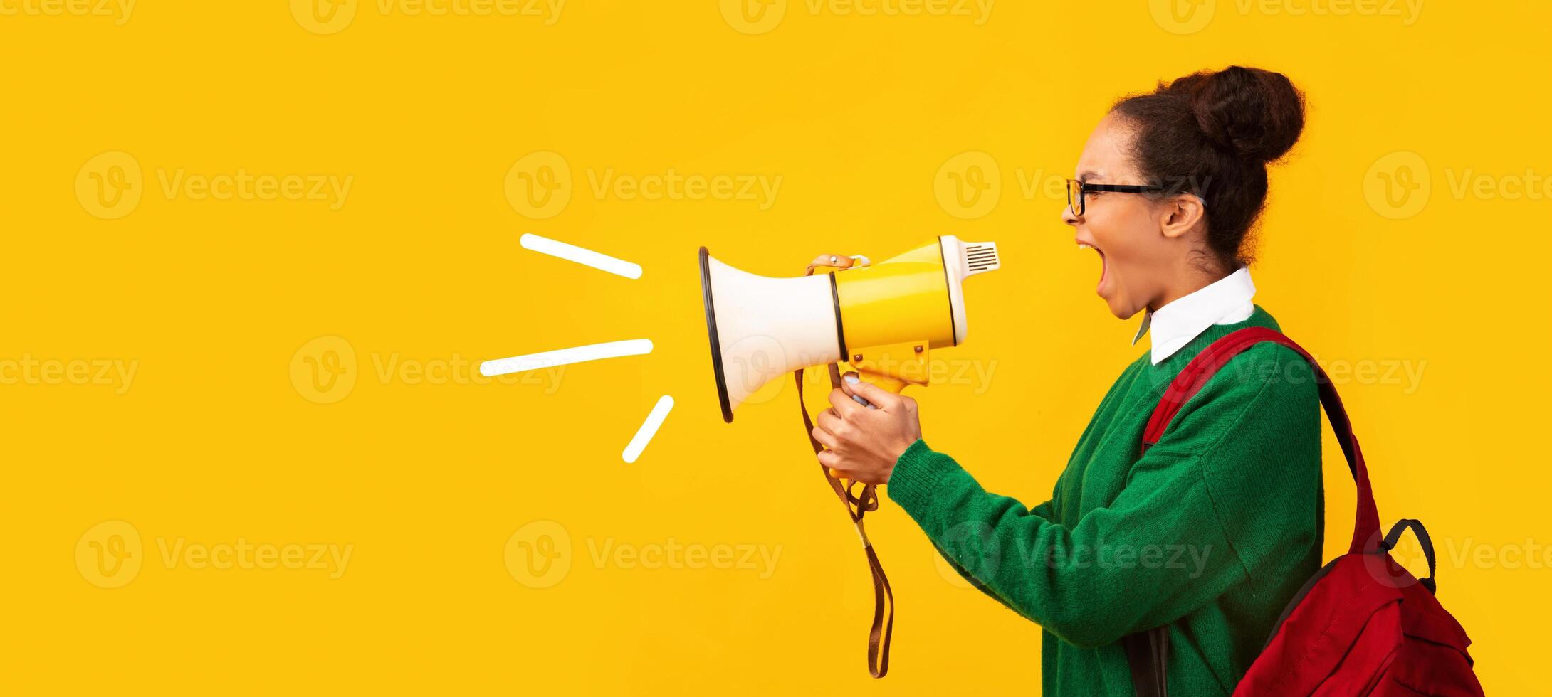 Attention. Black teen girl with megaphone screaming isolated over yellow background, panorama photo