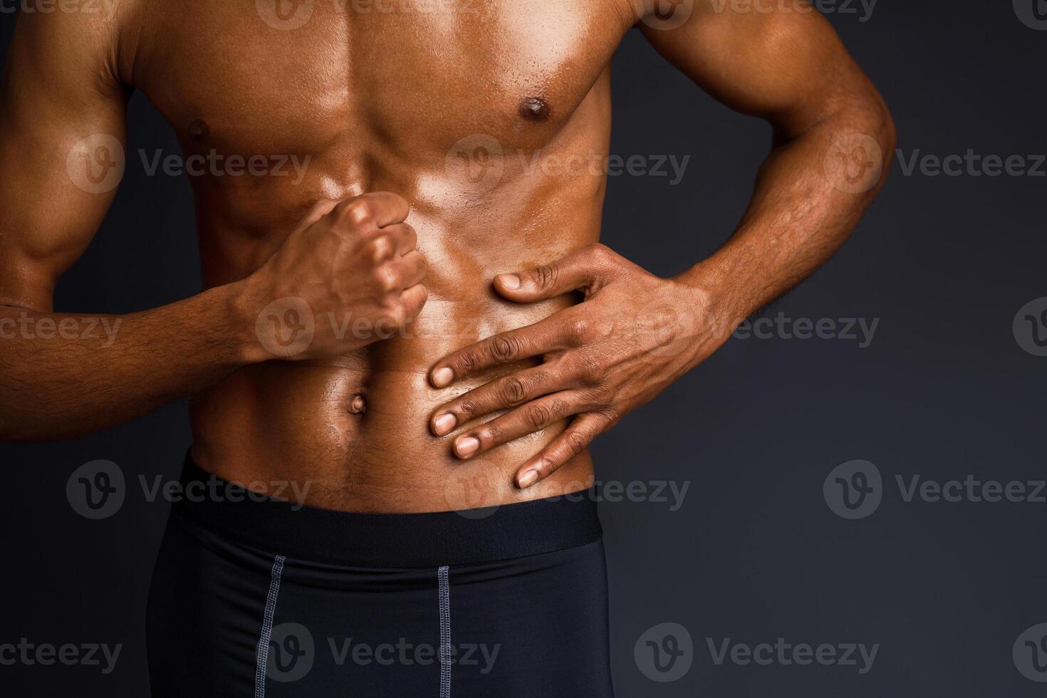 Naked Torso. Unrecognizable black man showing muscular body and six pack abs over black background with copyspace photo