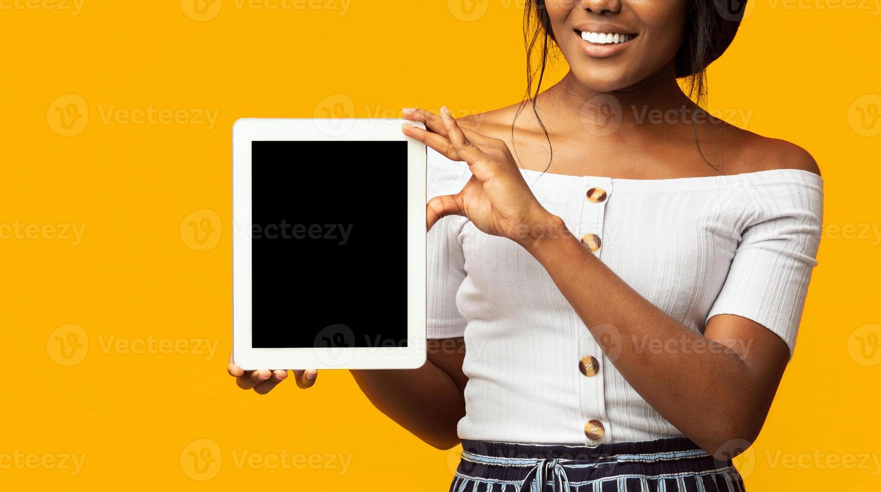 Great Application. Unrecognizable Girl Showing Tablet Computer Empty Screen Standing On Orange Background. Cropped, Panorama, Mockup photo