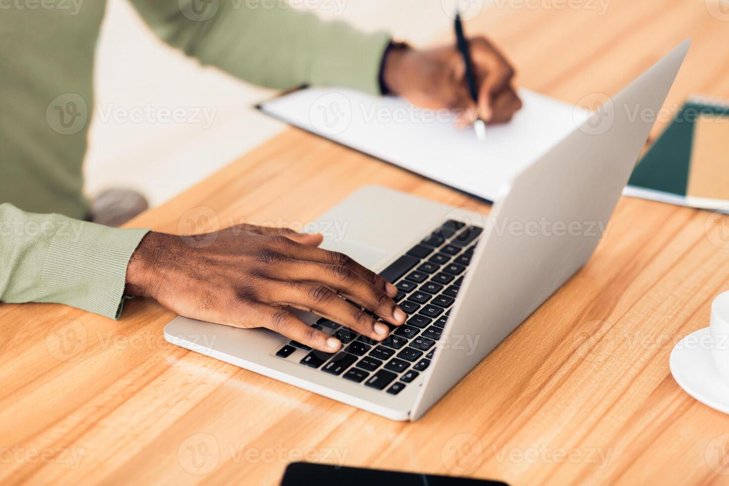 Information Searching. Unrecognizable black businessman working at laptop and writing notes in office, close-up of hands photo