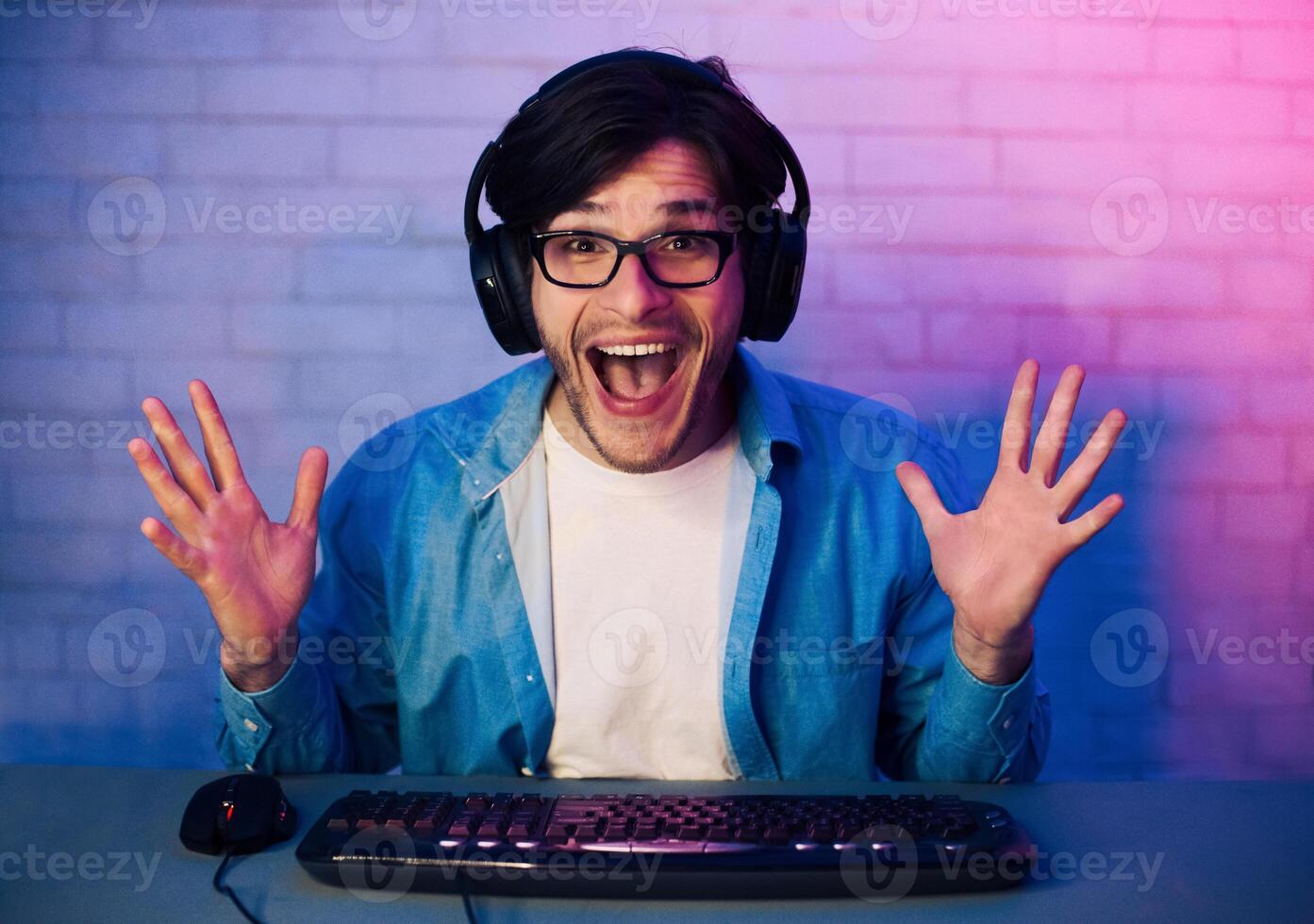 Happy Delighted Young Man Wearing Eyeglasses Gamer Winning Online Computer Game, Looking At Camera photo