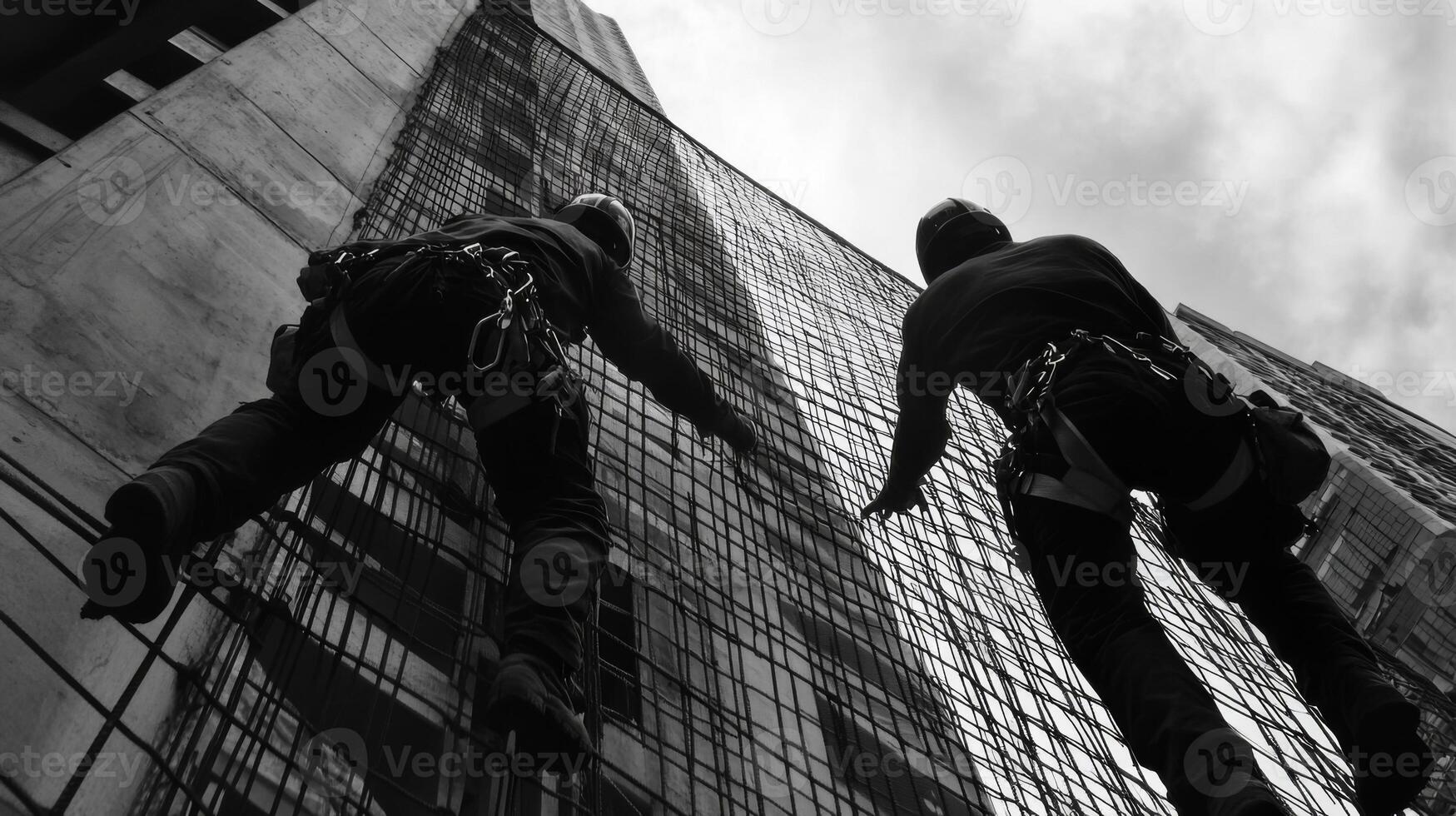 Two Workers Ascending a Concrete Building with Safety Nets photo