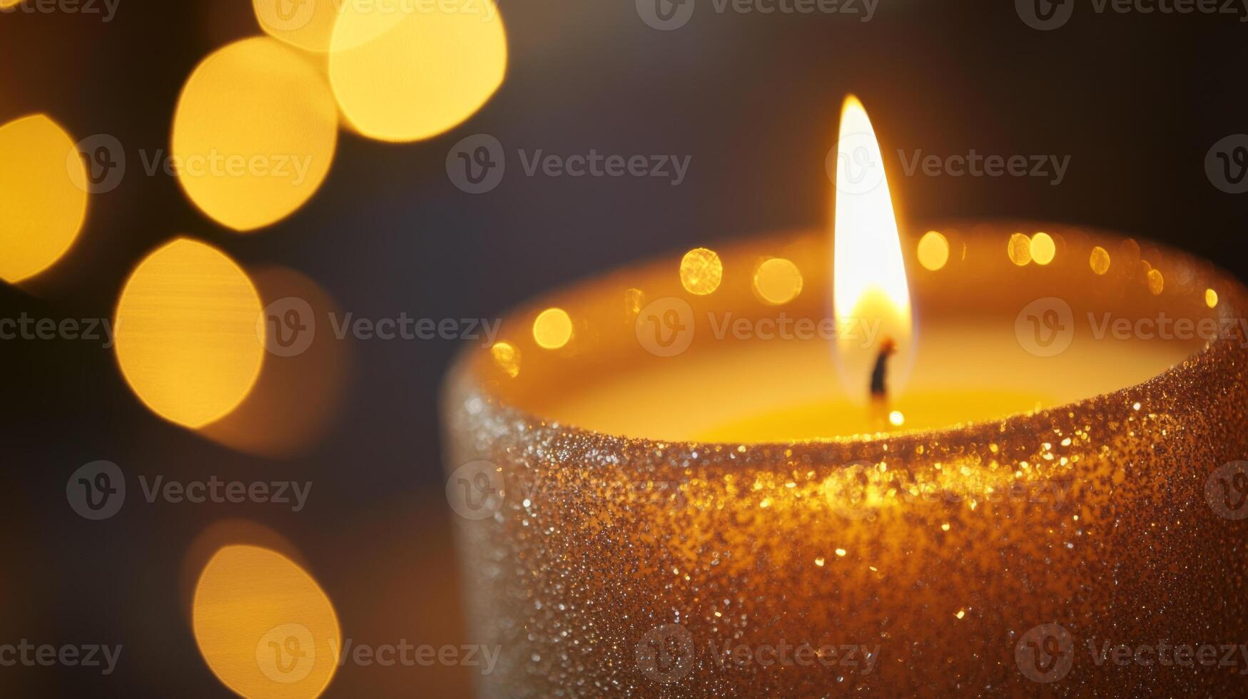 A Lit Glittery Candle with a Warm Glow and Blurry Lights in the Background photo