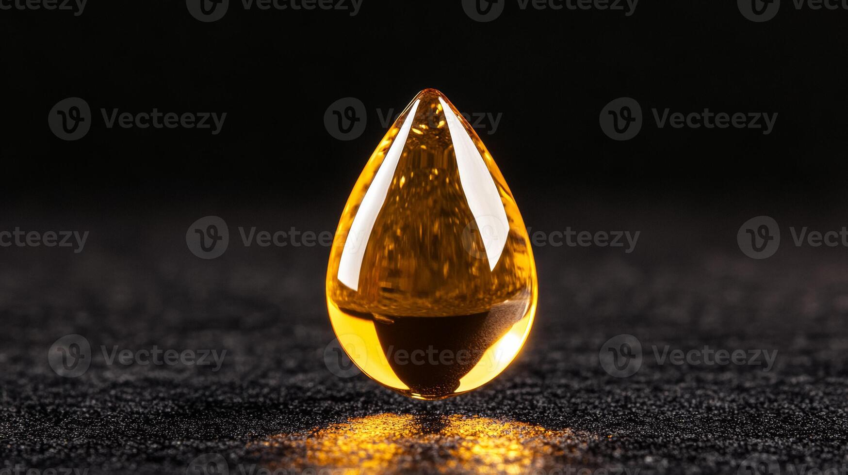 Golden facial oil drop glistening against a matte black background capturing light through its transparent form photo