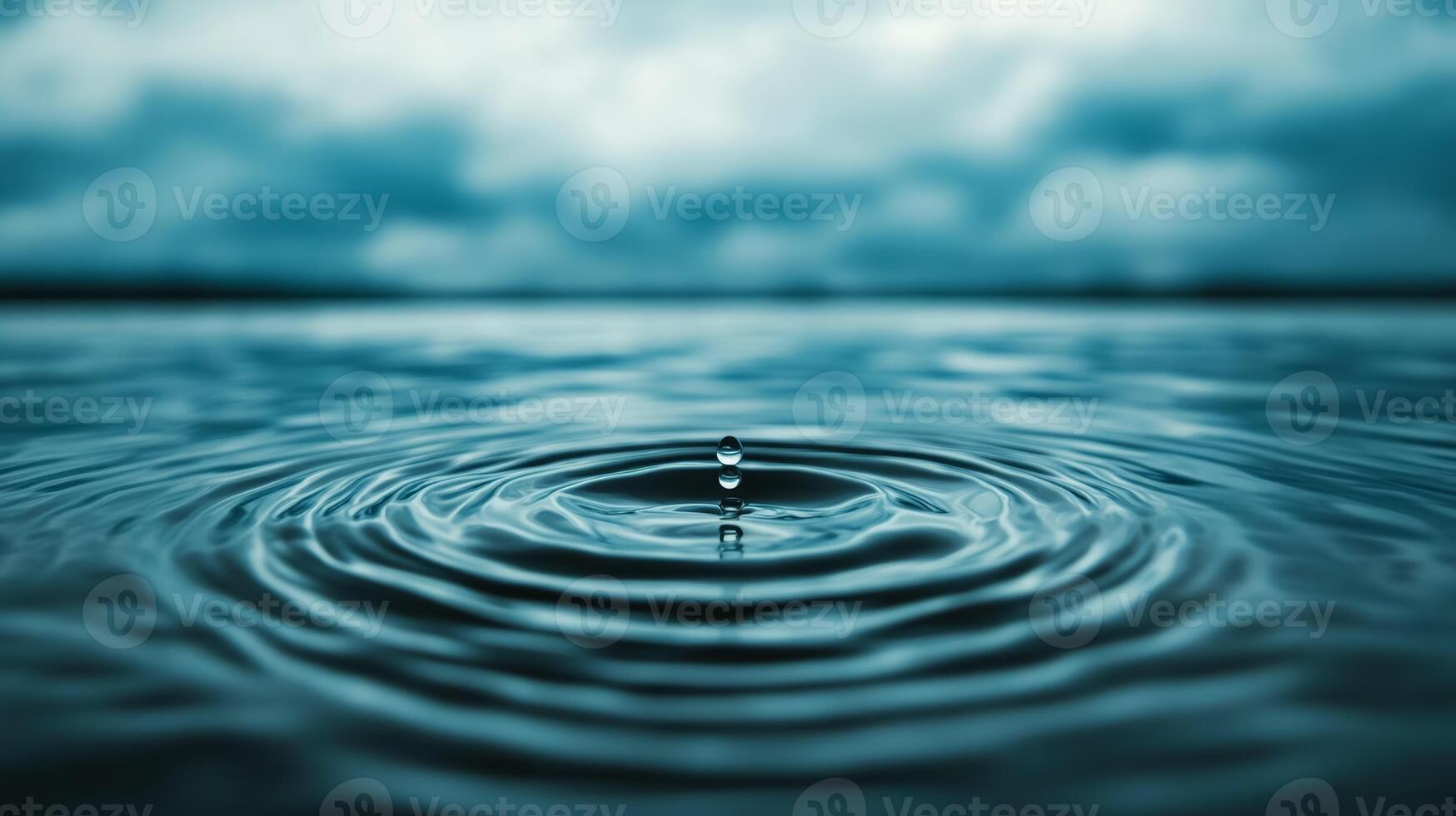 Close up of raindrop ripples on a calm lake surface under a cloudy sky photo