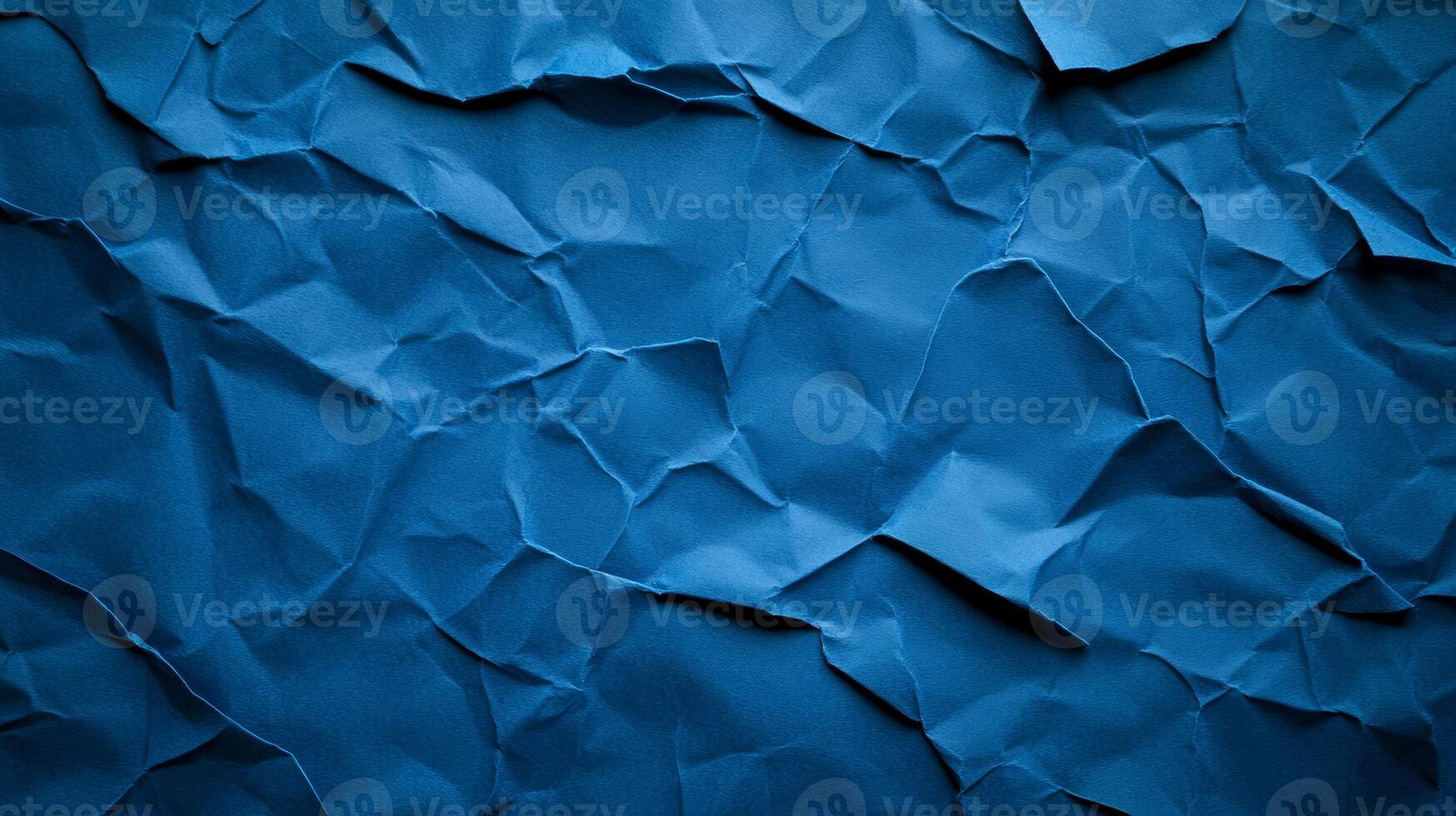 Crinkled blue paper background with deep creases and shadows creating a textured worn effect photo