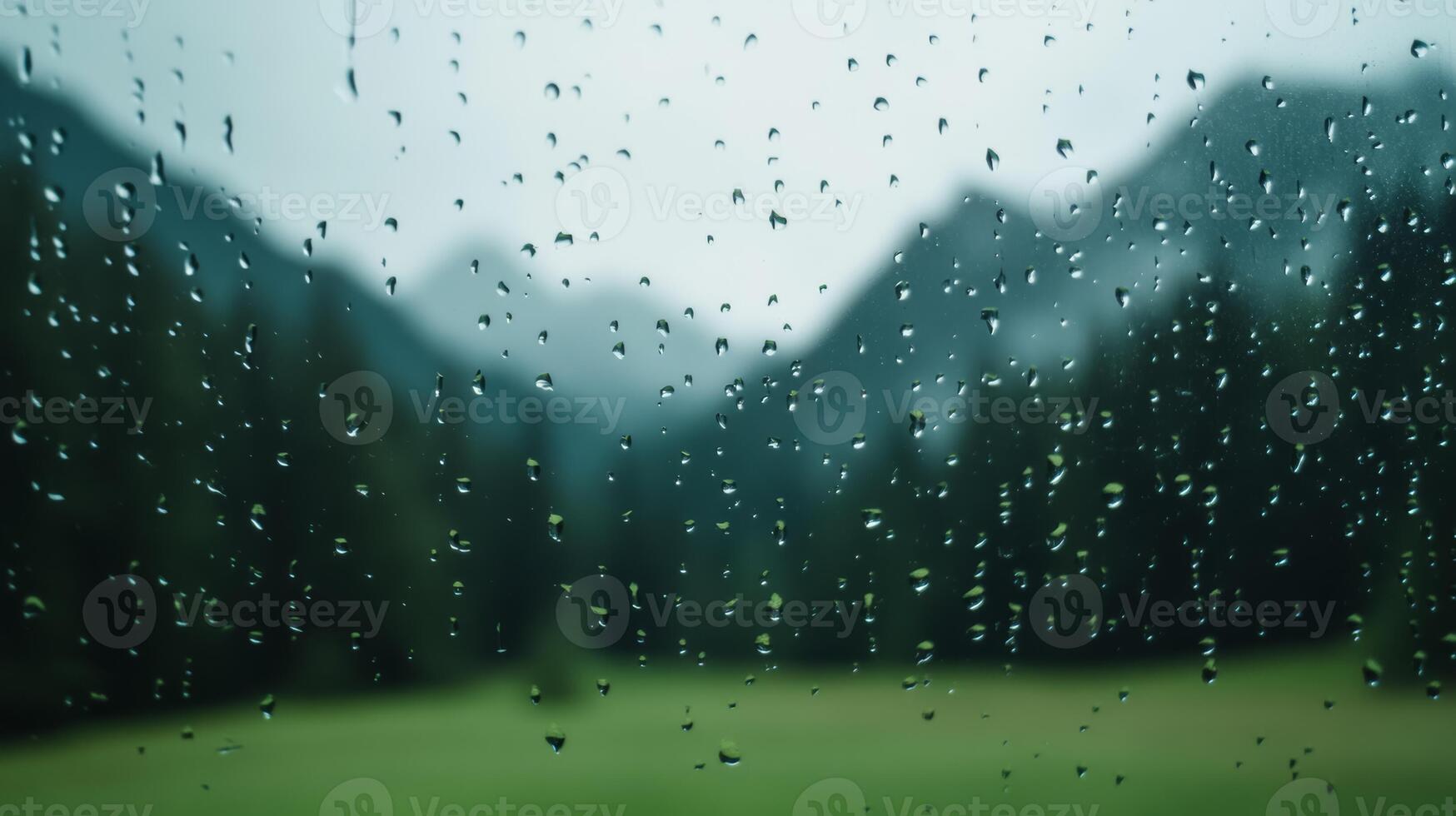 Raindrops on a fogged window with a distant mountain landscape barely visible in the background photo
