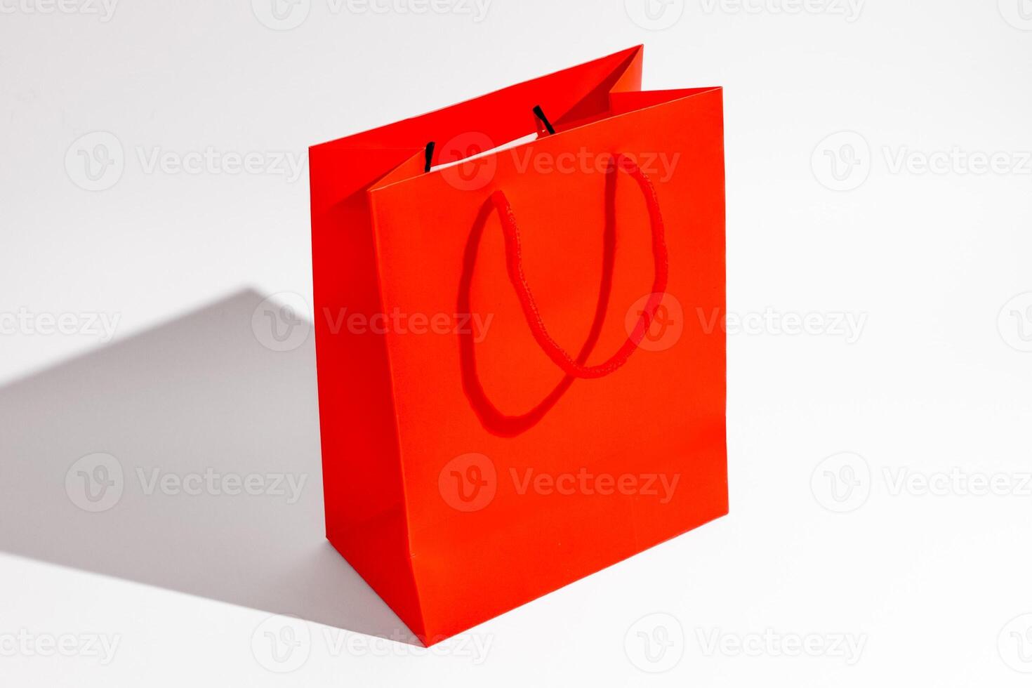 Red shopping bag on a white background, perfect for Christmas gift concepts and holiday shopping promotions photo