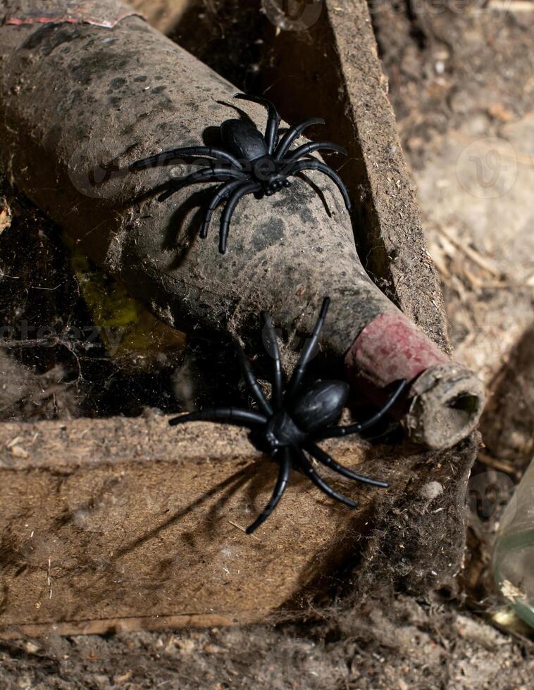 Dusty wine bottle with plastic spiders evokes Halloween spooky vibes and symbolizes aging and neglect photo