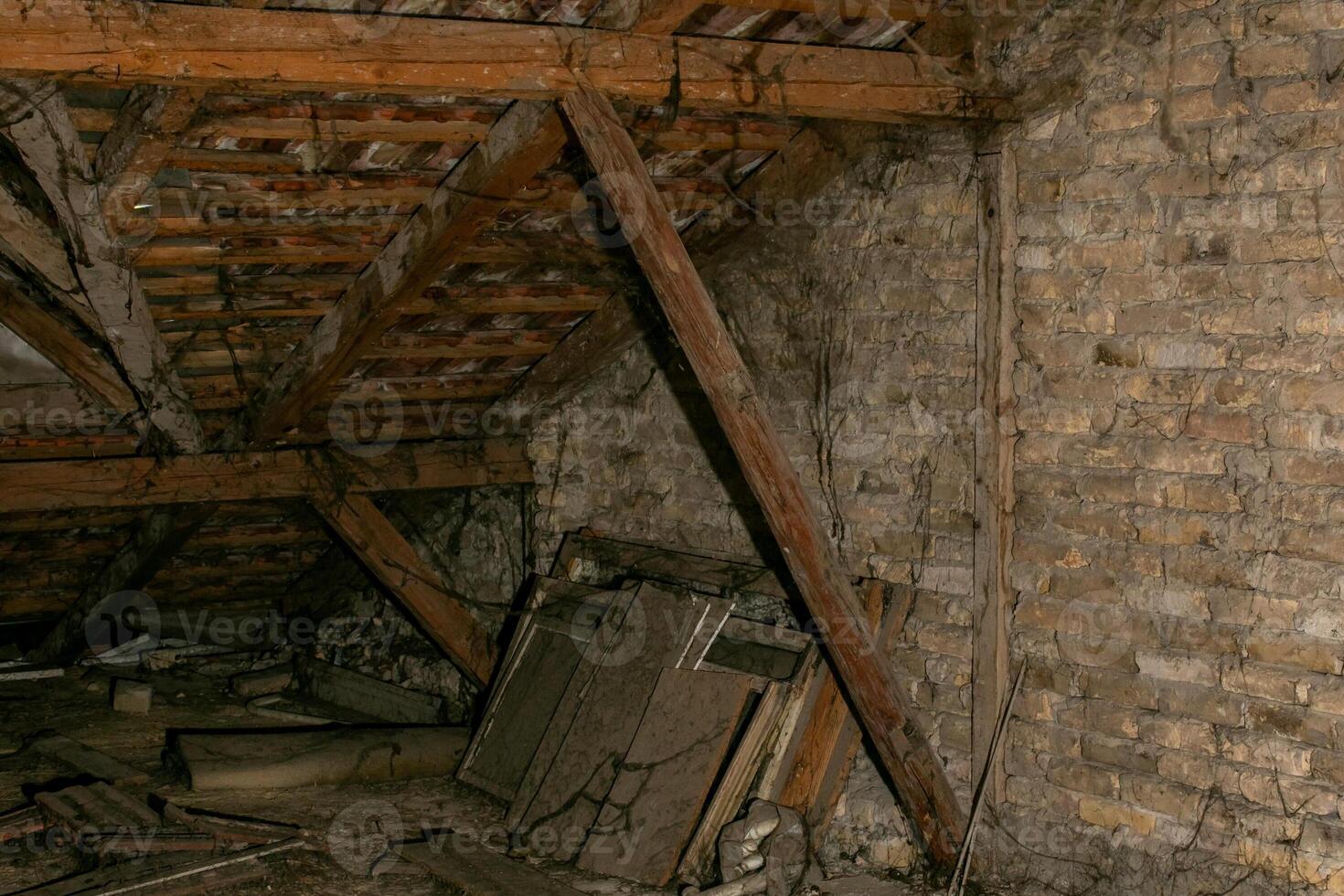 Old, cluttered attic with wooden beams and brick walls, perfect for concepts of disorganization, storage challenges, or Halloween photo