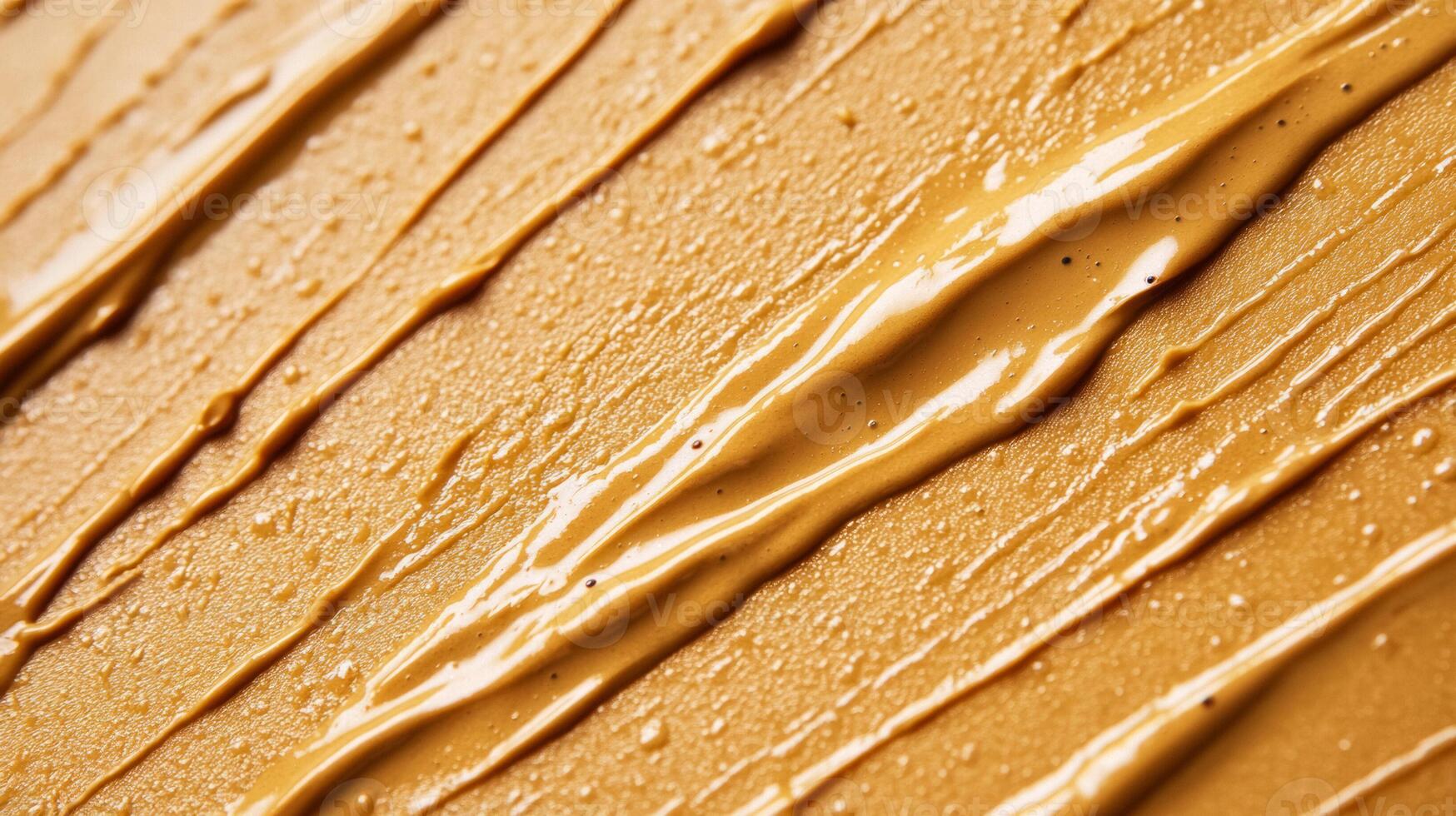 Closeup of golden brown eyebrow gel with tiny microfibers creating a textured pattern against a light tan background photo