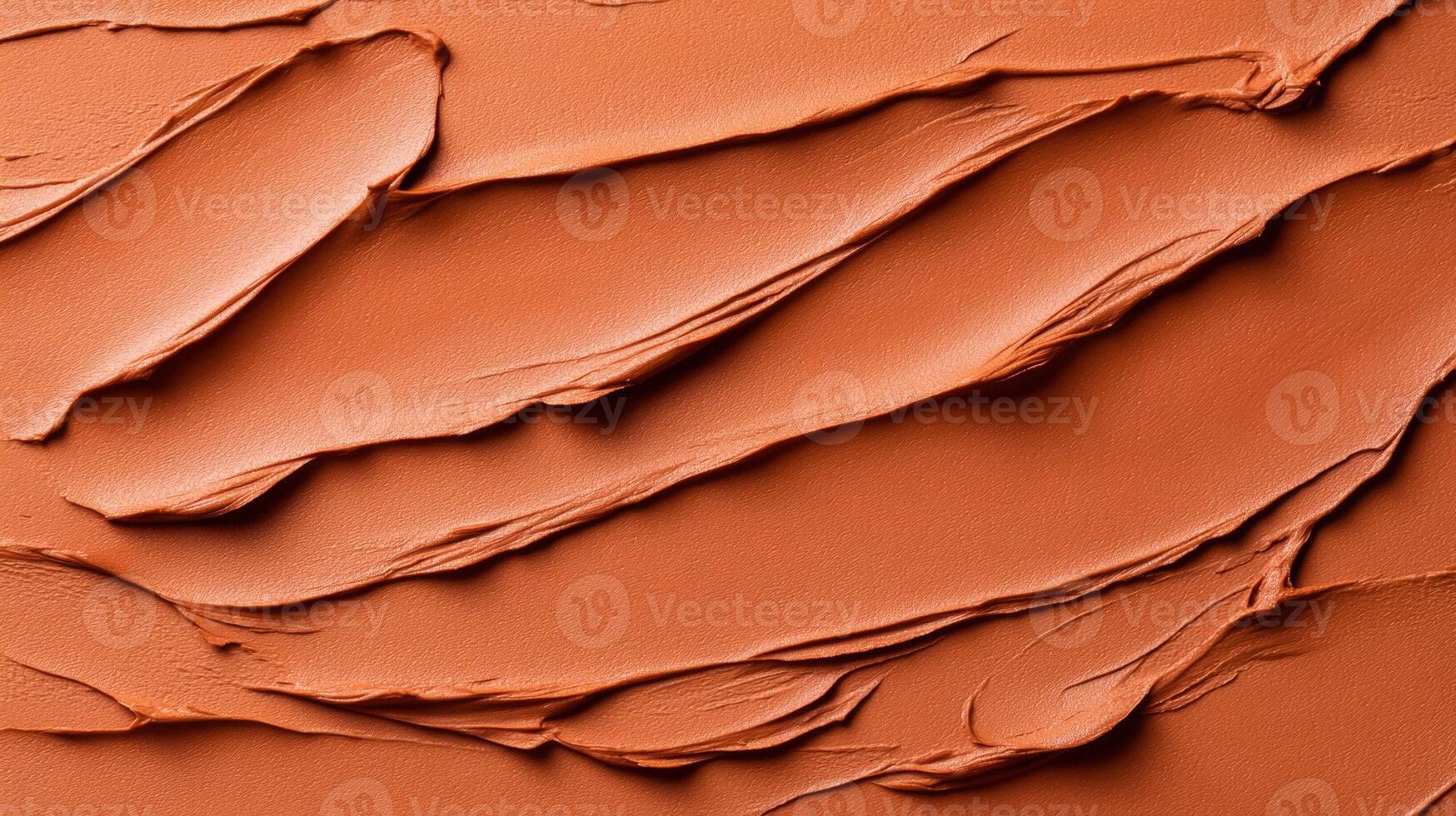 Closeup of terracotta clay mask smeared in rough organic lines on a smooth beige background photo