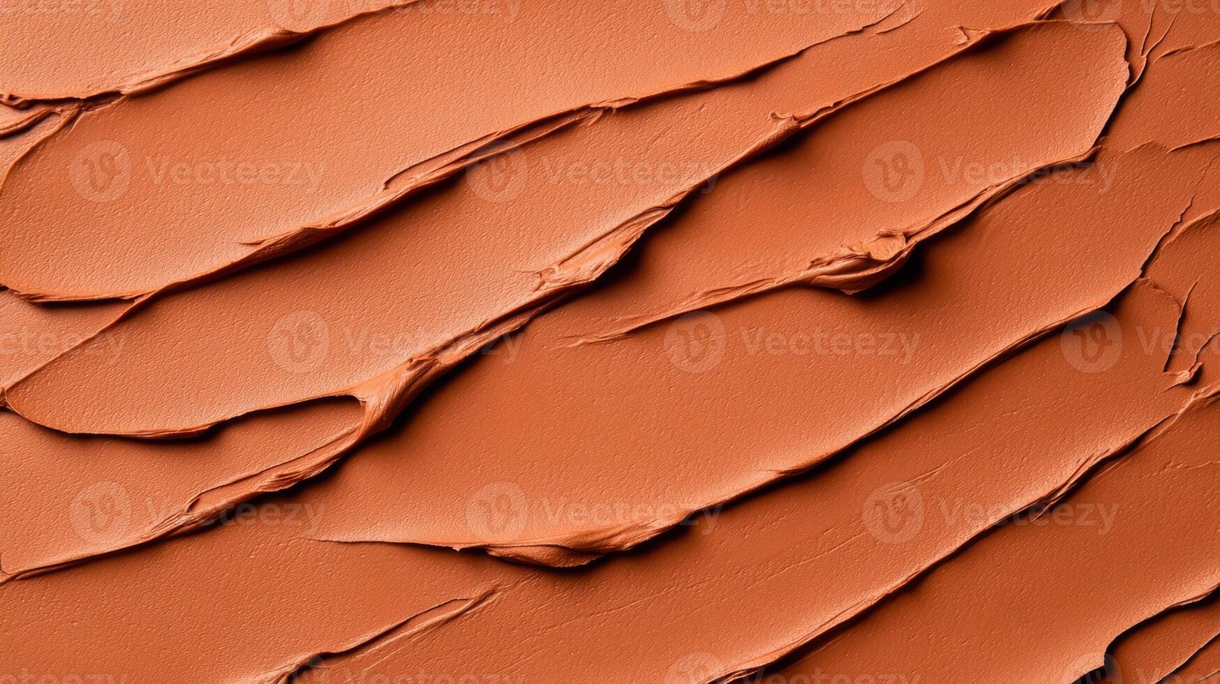 Closeup of terracotta clay mask smeared in rough organic lines on a smooth beige background photo