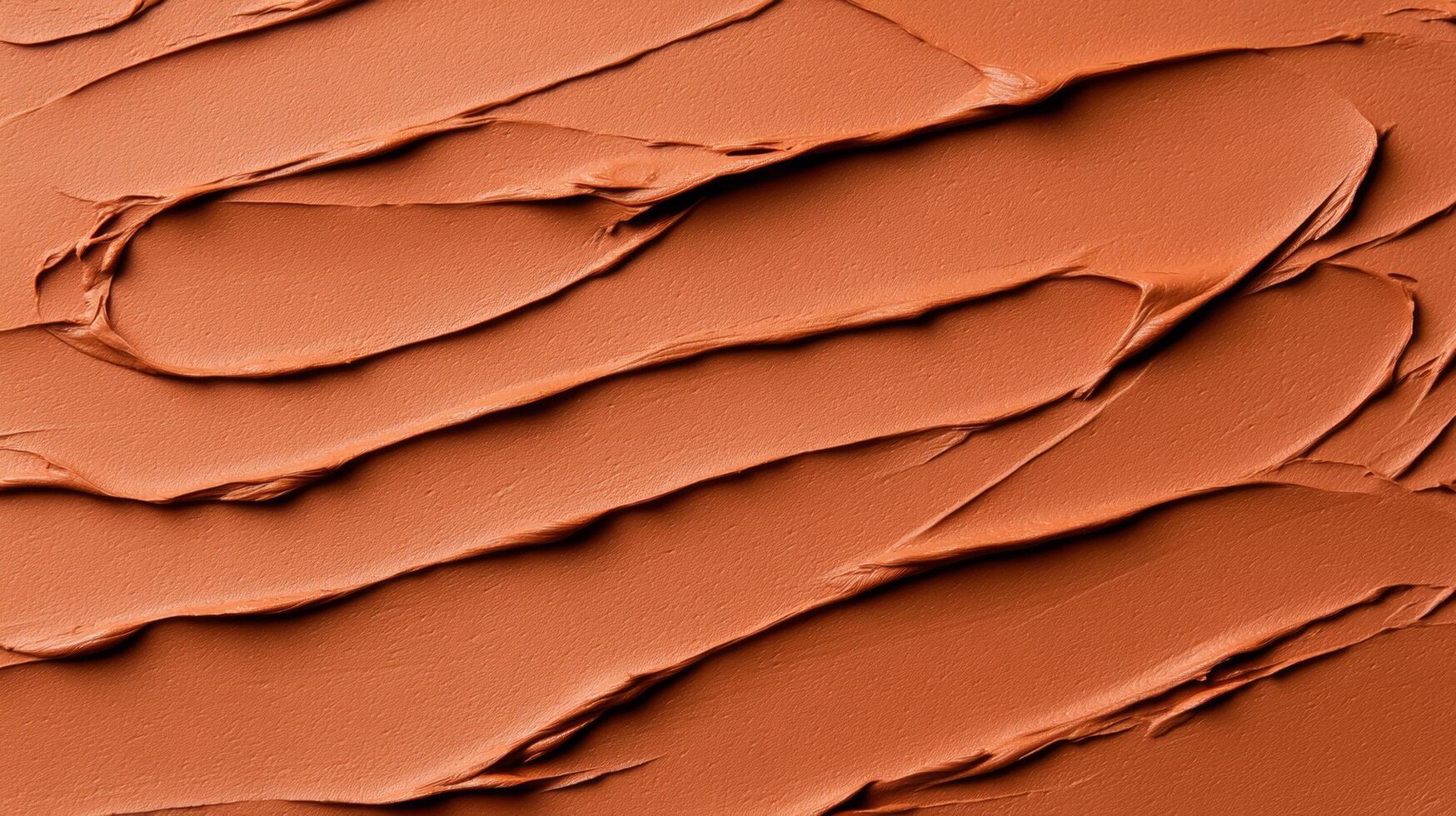 Closeup of terracotta clay mask smeared in rough organic lines on a smooth beige background photo