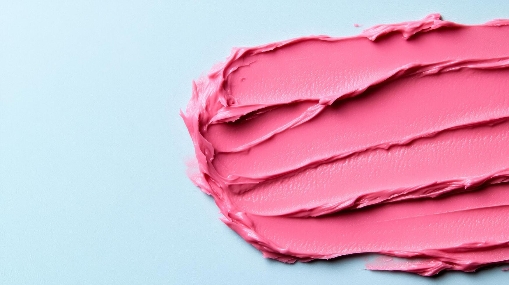 Frosted pink lip balm smear with a subtle sheen on a soft grey blue background mimicking winter morning light photo