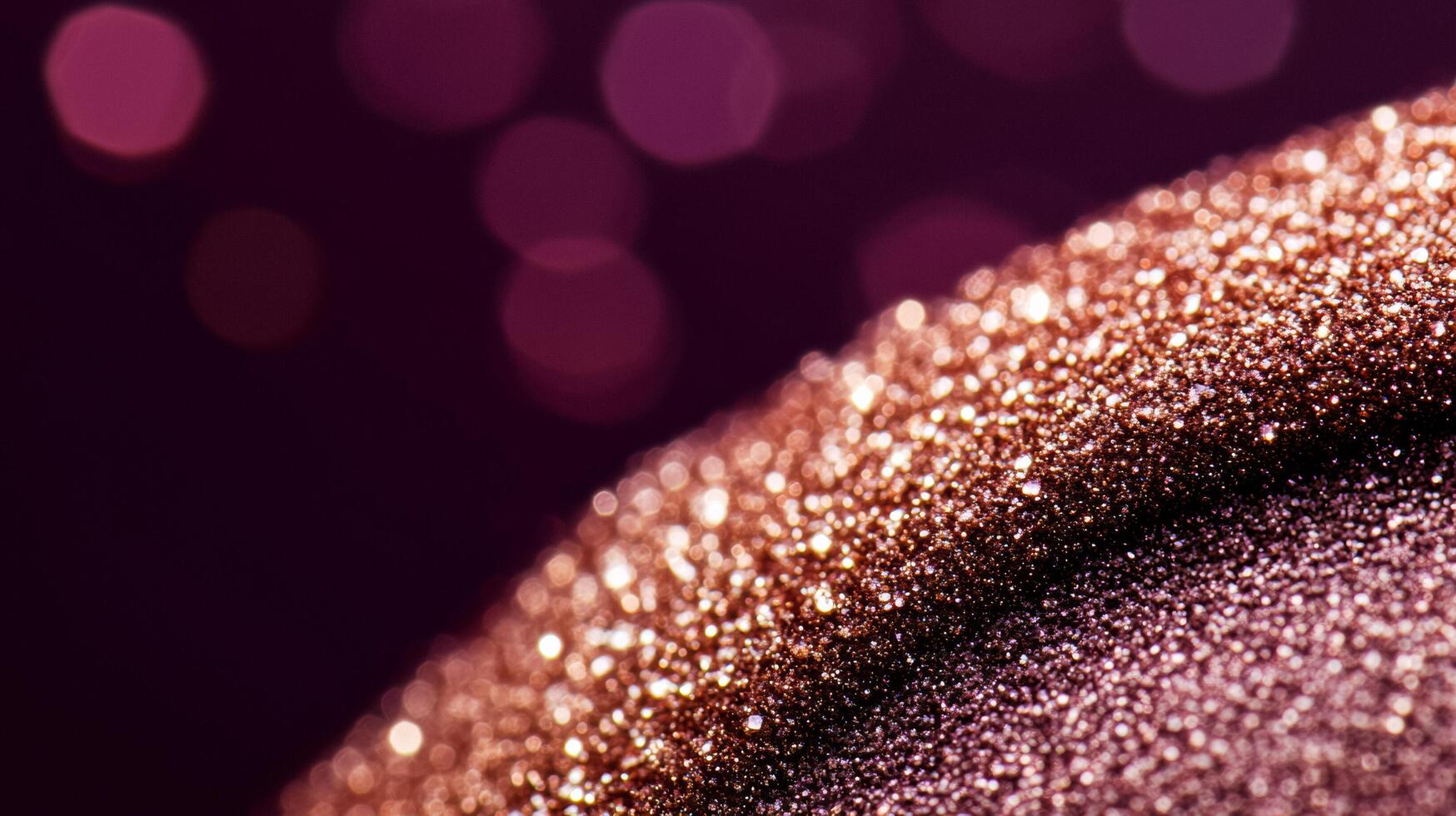Macro of warm taupe eyeshadow with hints of gold sparkles blending into a deep plum background photo