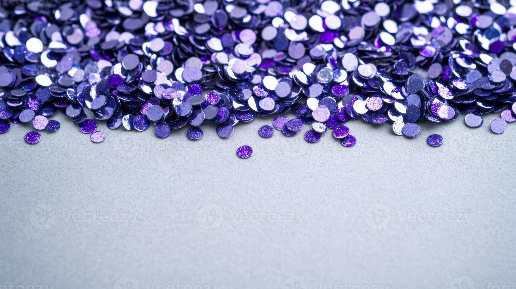 Silver and lavender glitter pigment scattered in delicate speckles on a light slate grey surface photo