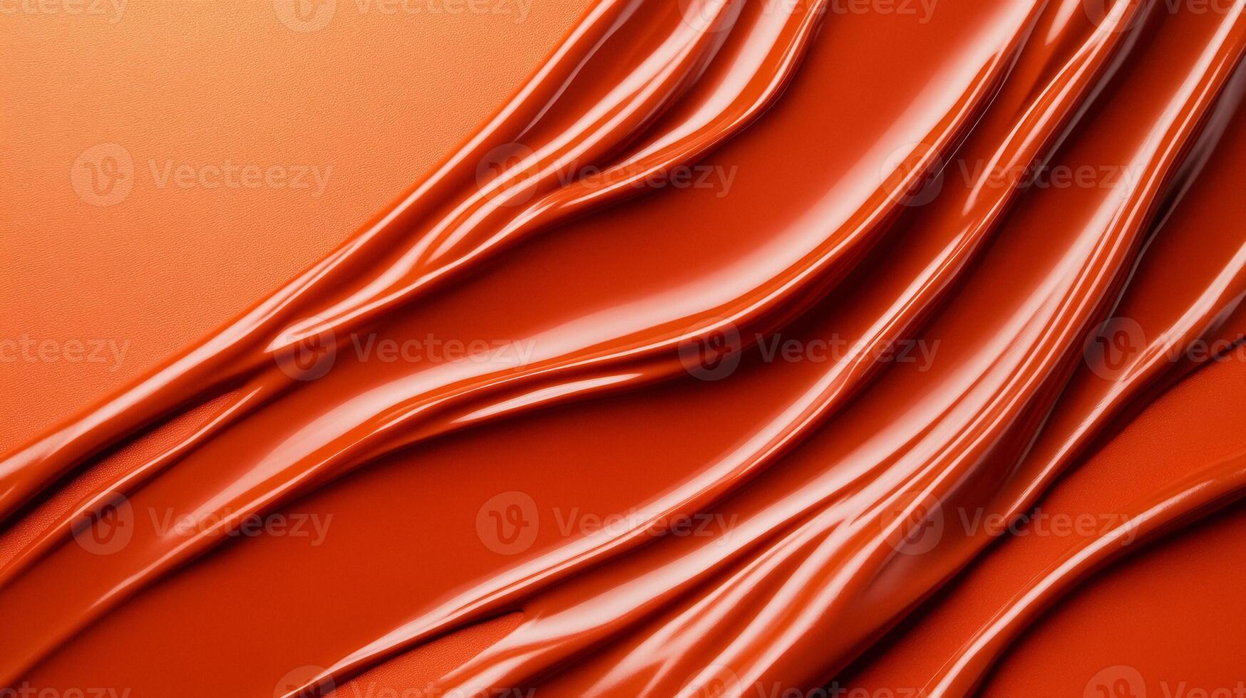 Swirls of rich coppery red liquid lipstick creating an abstract pattern on a soft muted orange background photo