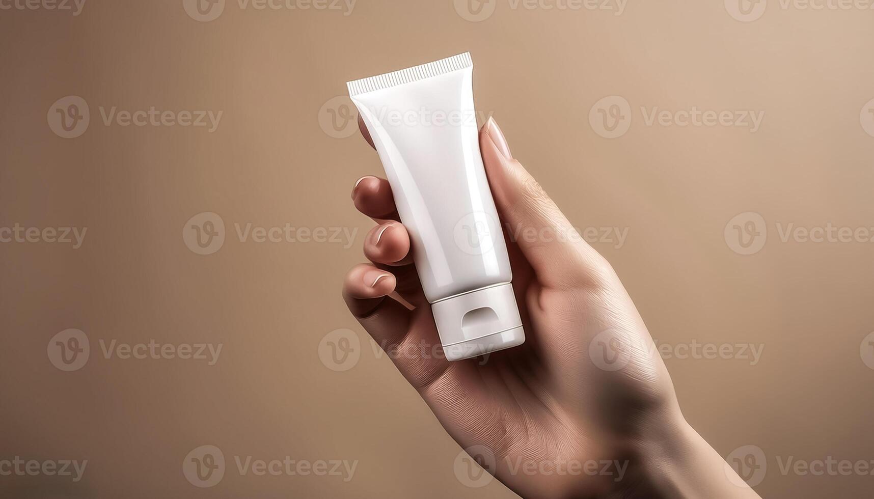 Fragile female hand holding blank mockup tube for cream or lotion on beige isolated background photo