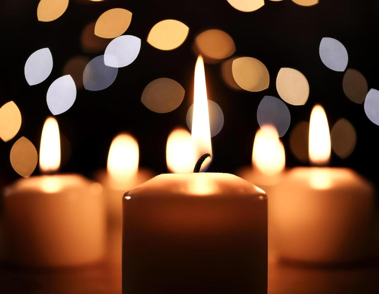 burning candles in the dark against the background of blurry lights photo