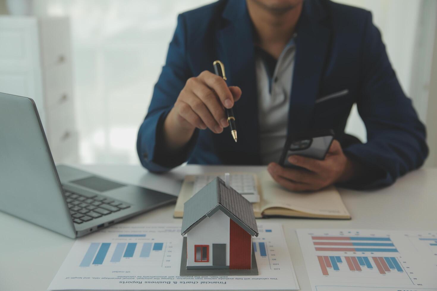 Businessmen holding pens, signing home titles with insurance, care about real estate services and the idea of real estate agents offering interest in installments to their customers. photo