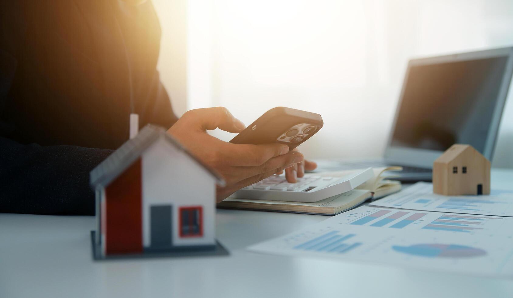 Businessmen holding pens, signing home titles with insurance, care about real estate services and the idea of real estate agents offering interest in installments to their customers. photo