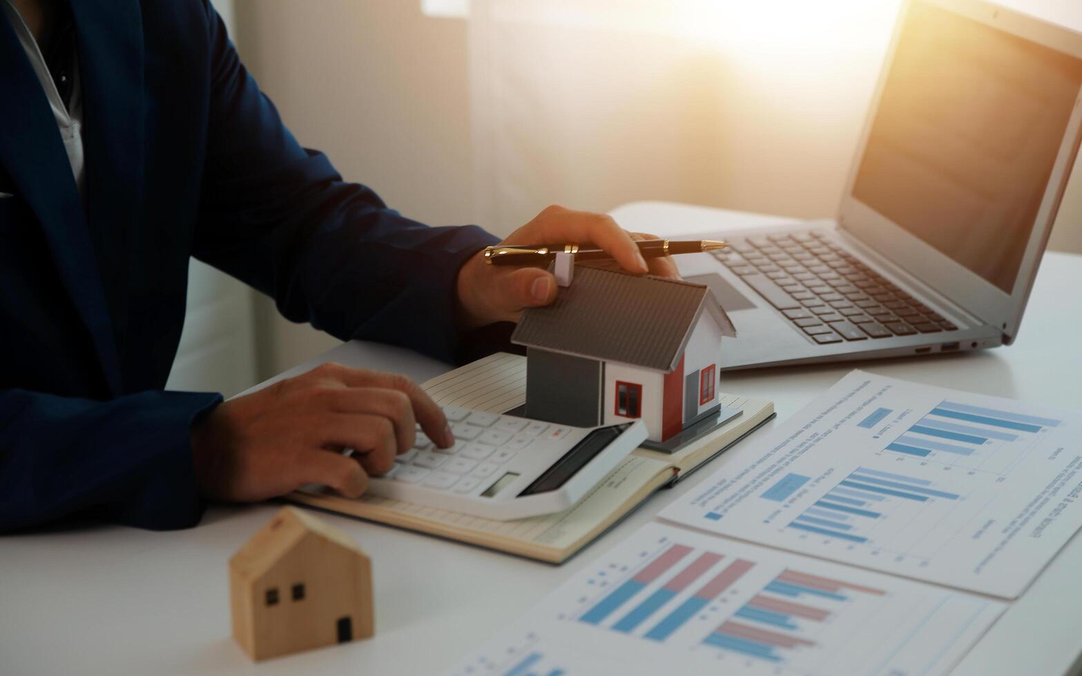 Businessmen holding pens, signing home titles with insurance, care about real estate services and the idea of real estate agents offering interest in installments to their customers. photo